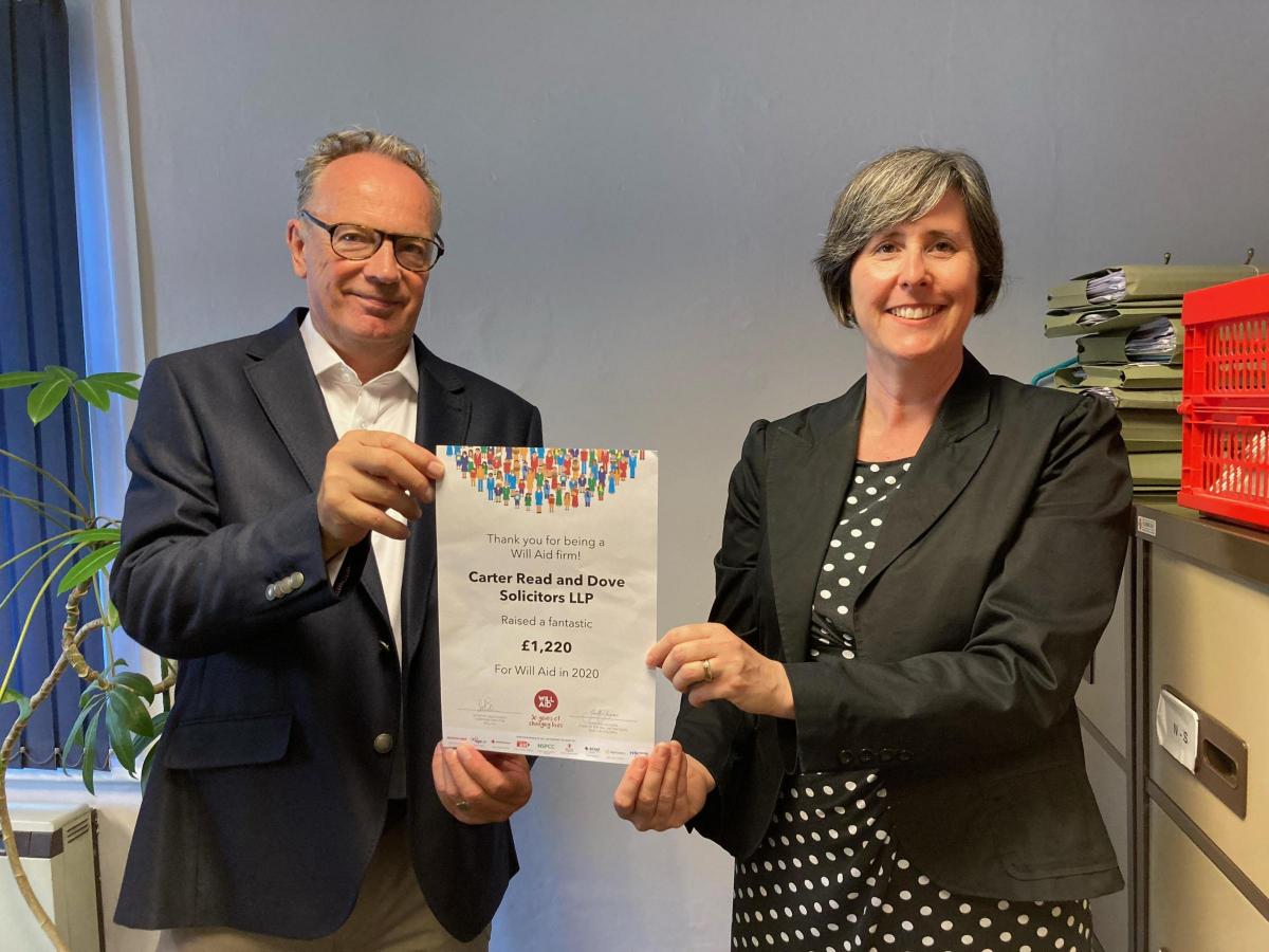 A man and a woman are holding a certificate in a room.