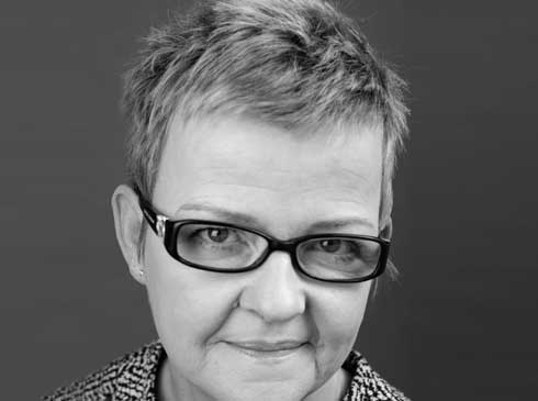 A black and white photo of a woman wearing glasses.