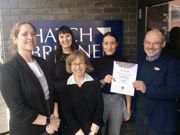 A group of people standing in front of a sign that says hatch