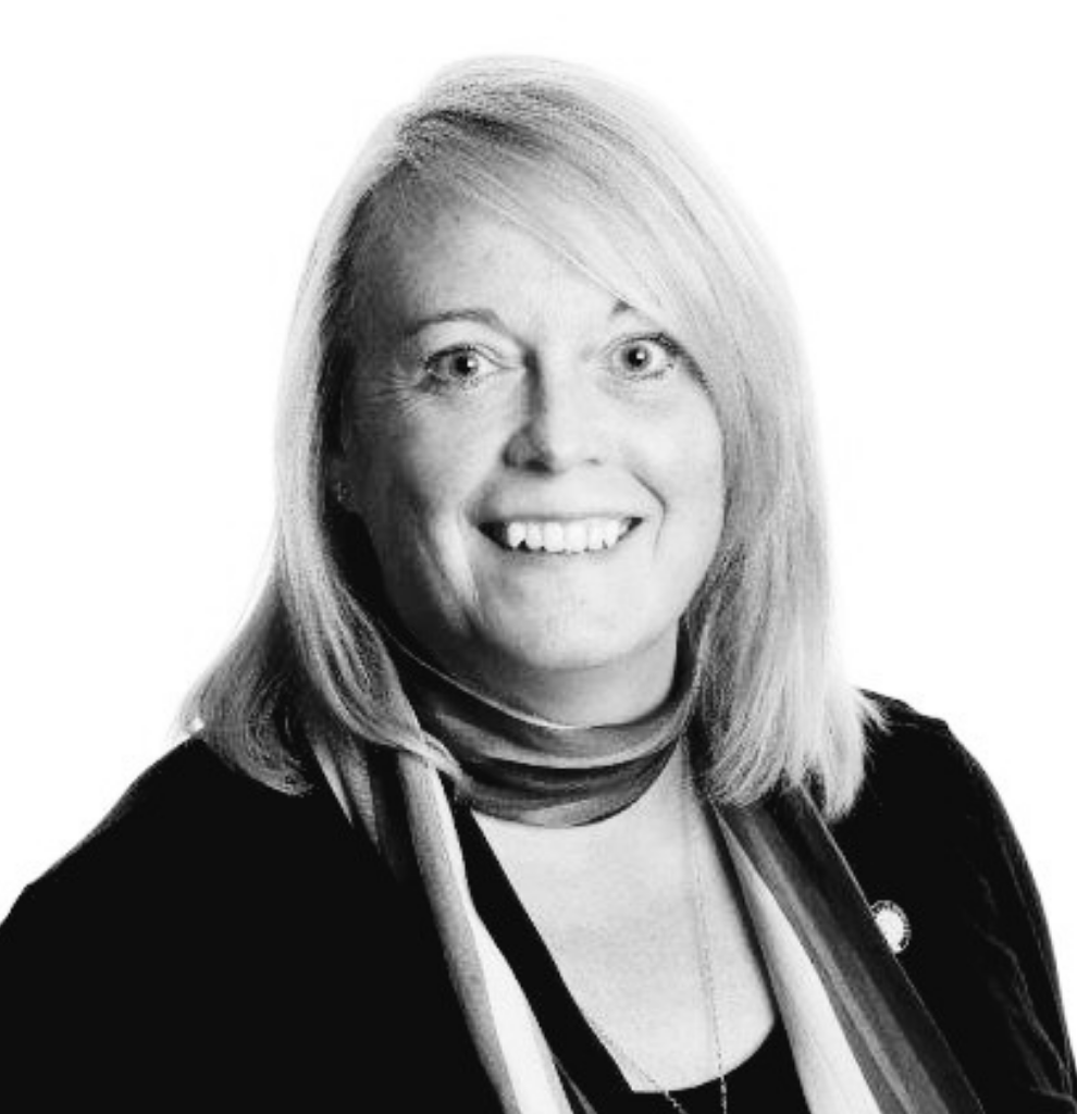 A black and white photo of a woman wearing a scarf and smiling.