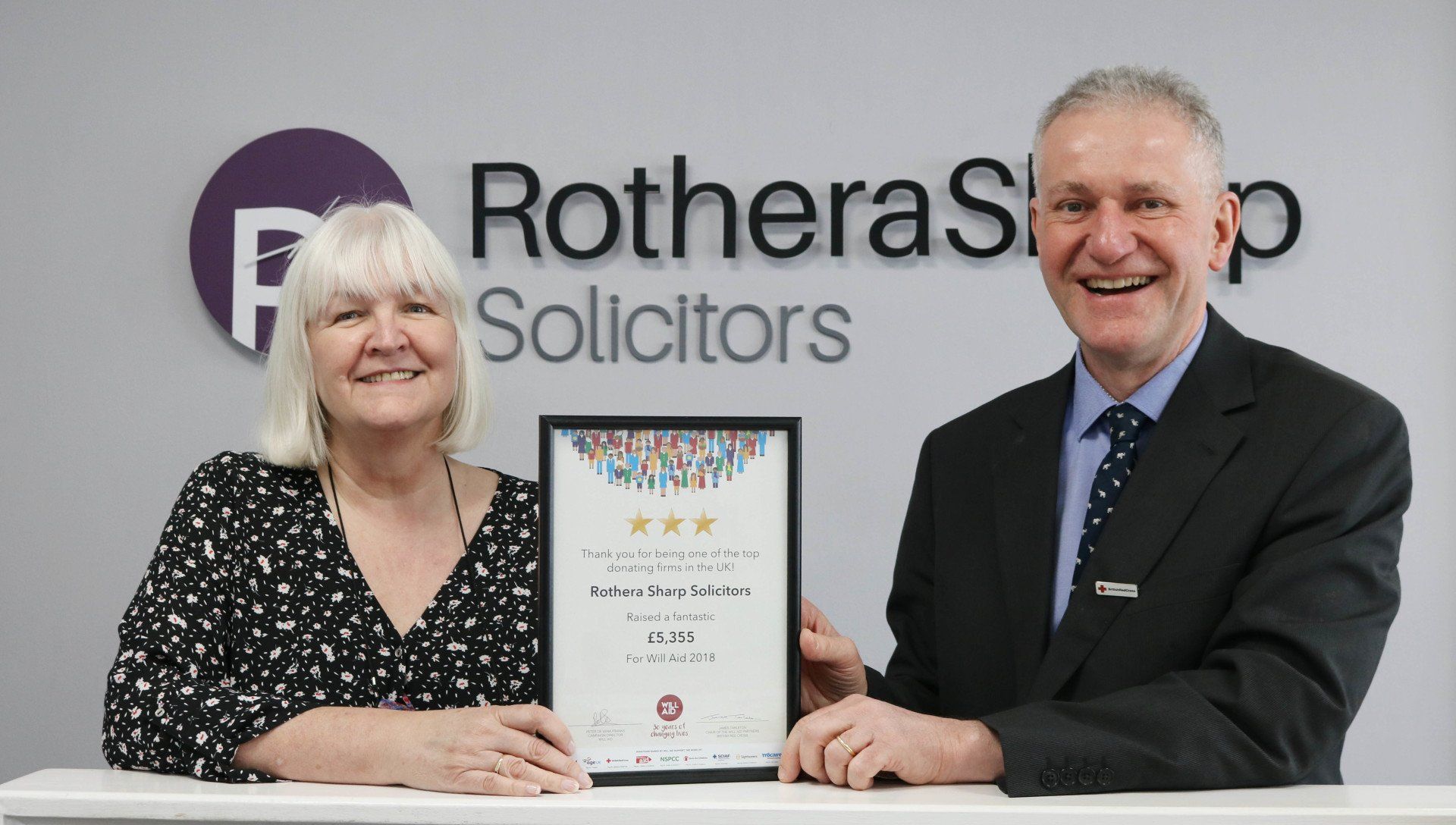 A man and a woman are standing next to each other holding a certificate.