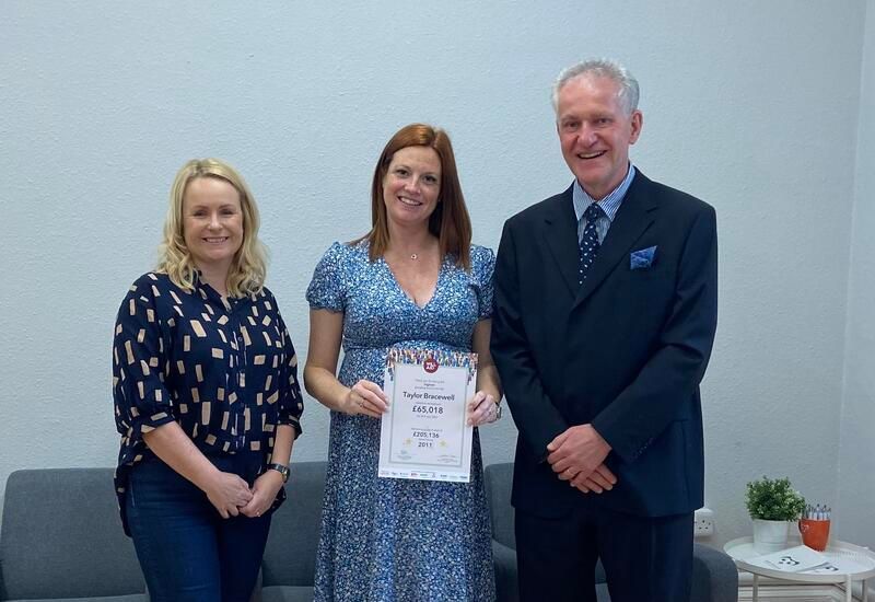A man and two women are standing next to each other holding a certificate.