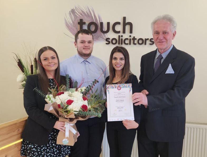 A group of people are standing in front of a sign that says touch solicitors.
