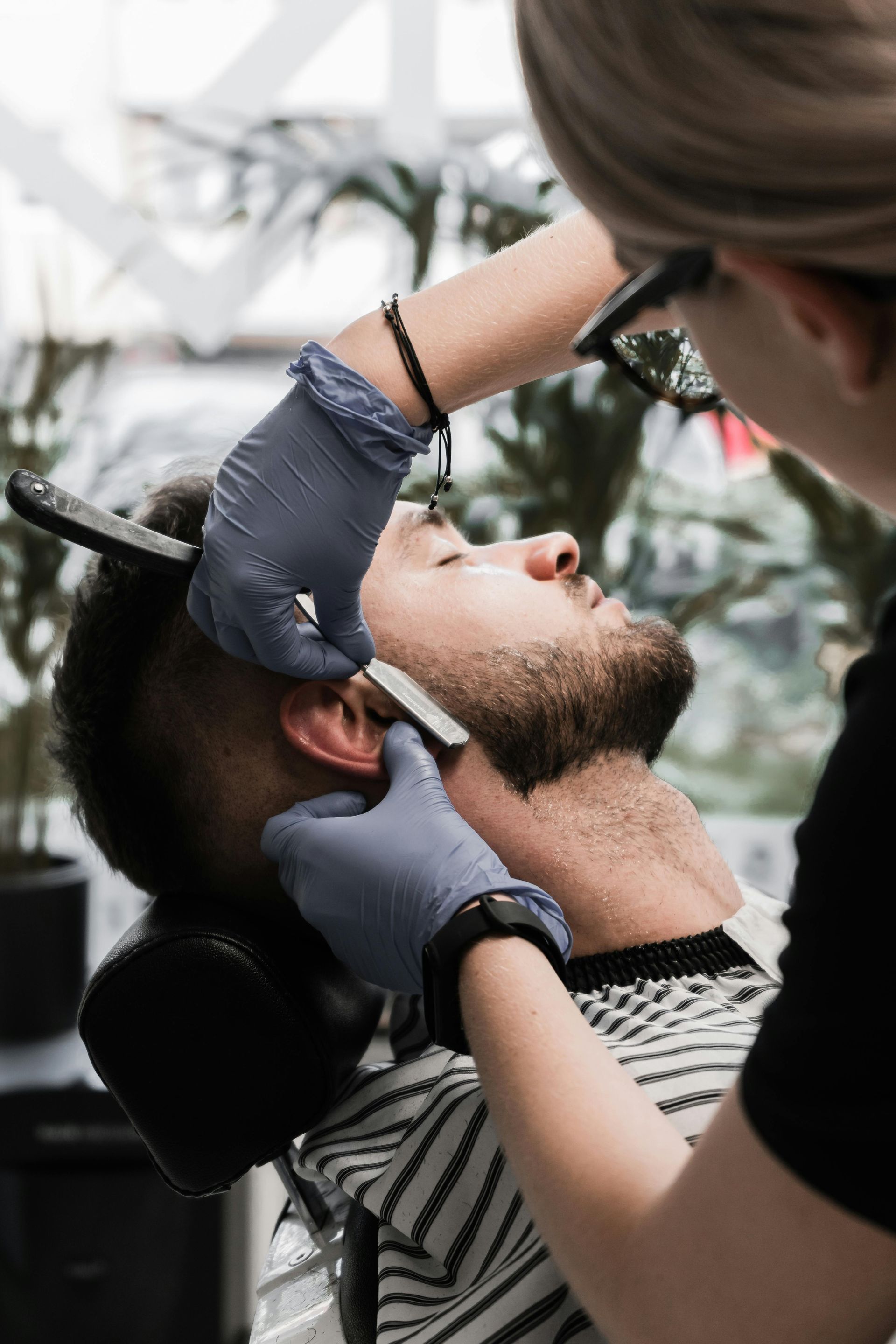 Dentist examining a patient's mouth with gloved hands in a clinic chair