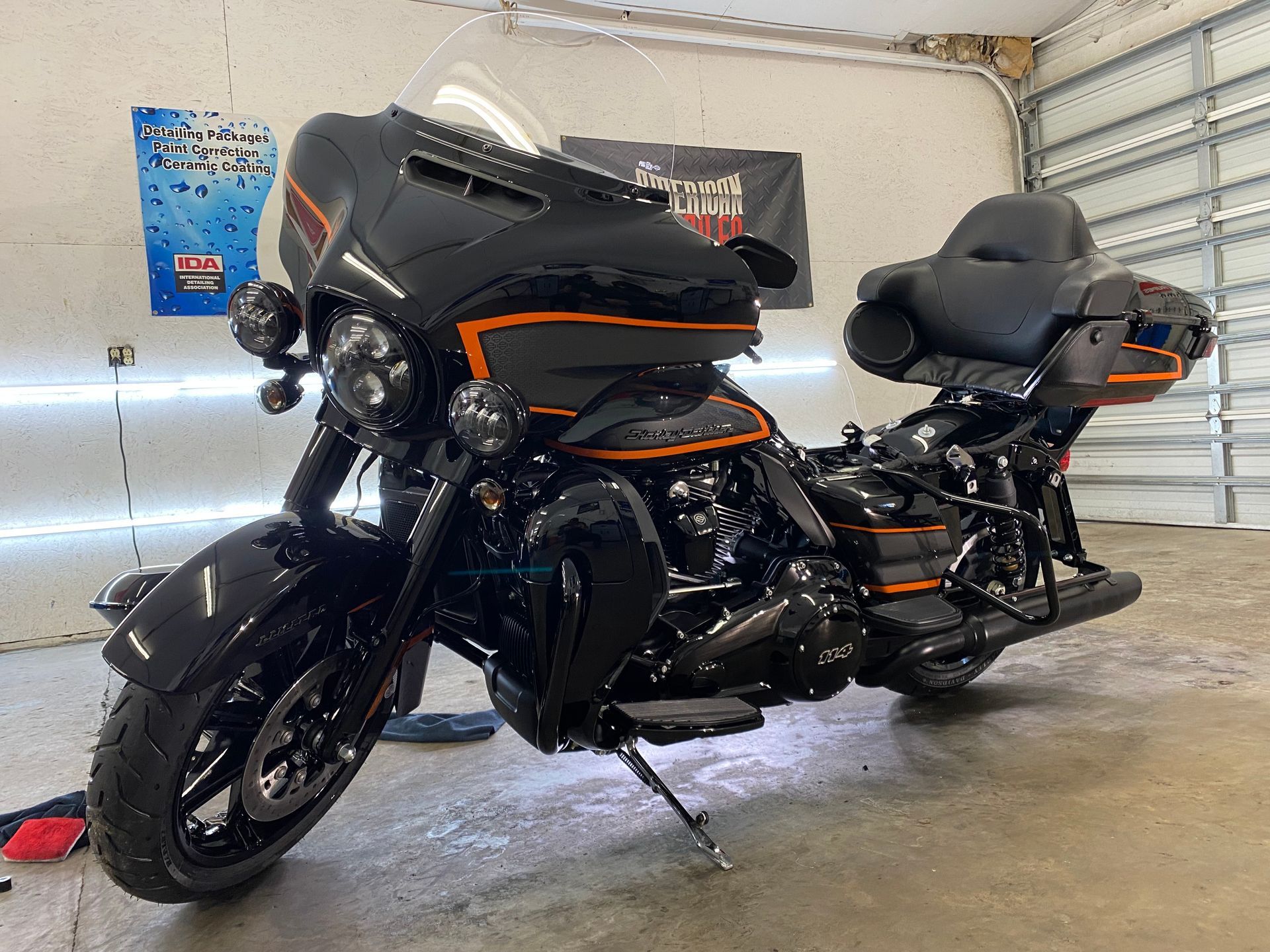 Black and orange Harley-Davidson motorcycle parked indoors, angled view.