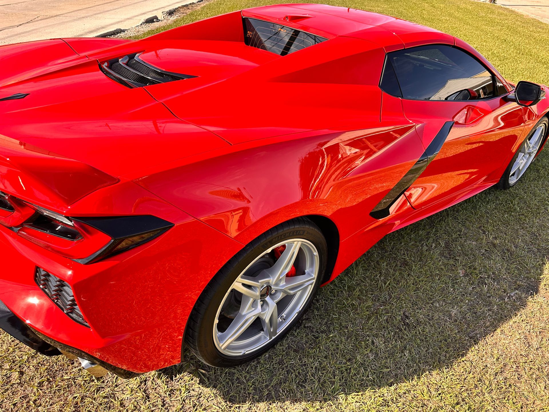 Red sports car on grass.
