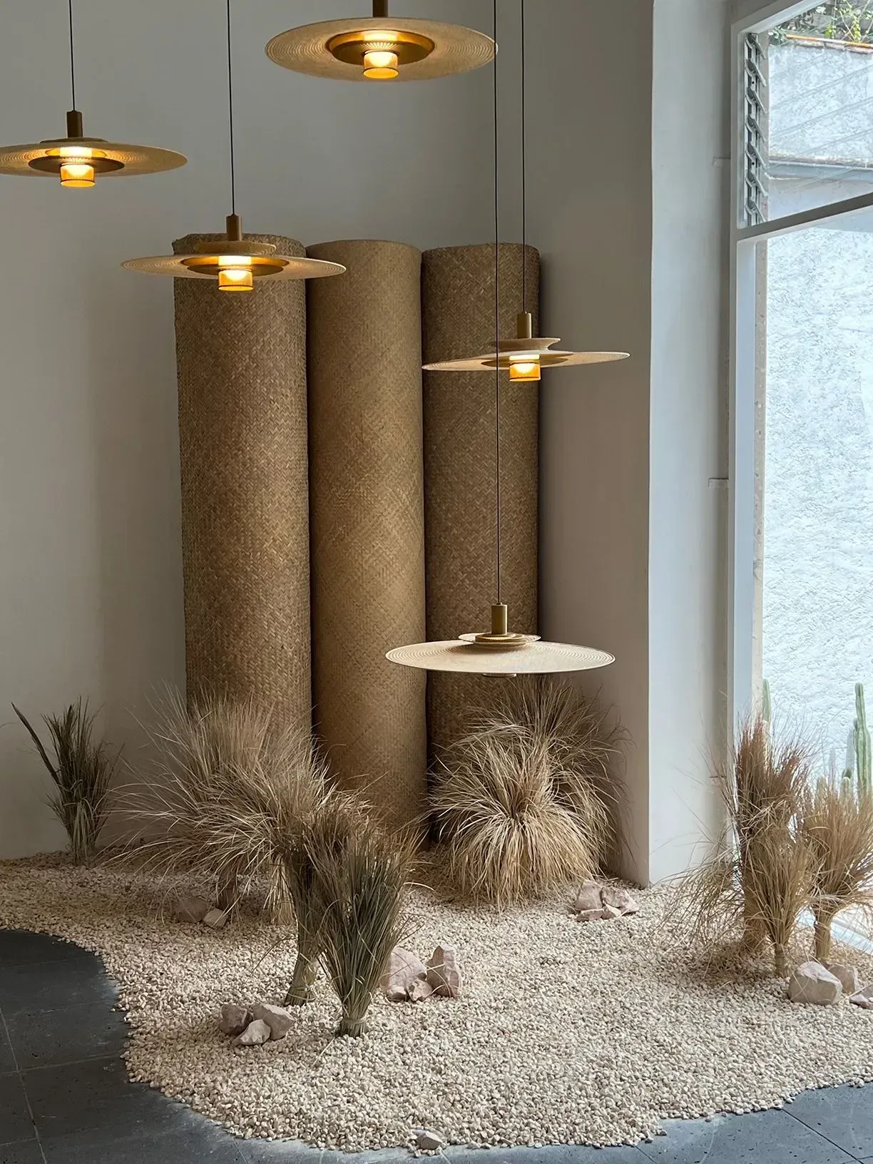 A room with a lot of plants and lamps hanging from the ceiling.