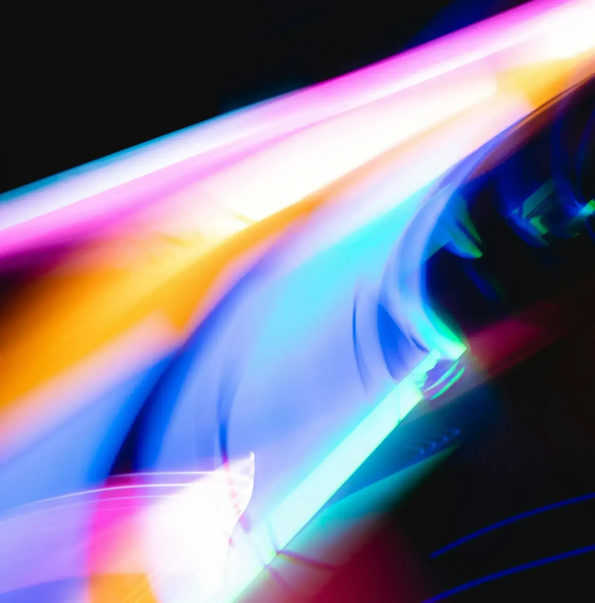 A close up of a colorful light beam on a black background.