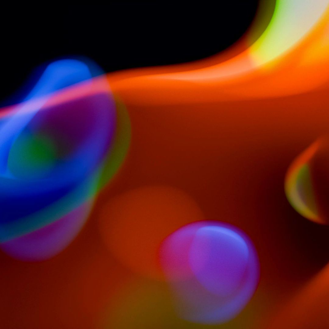 A blurry picture of a rainbow of colors on a black background.