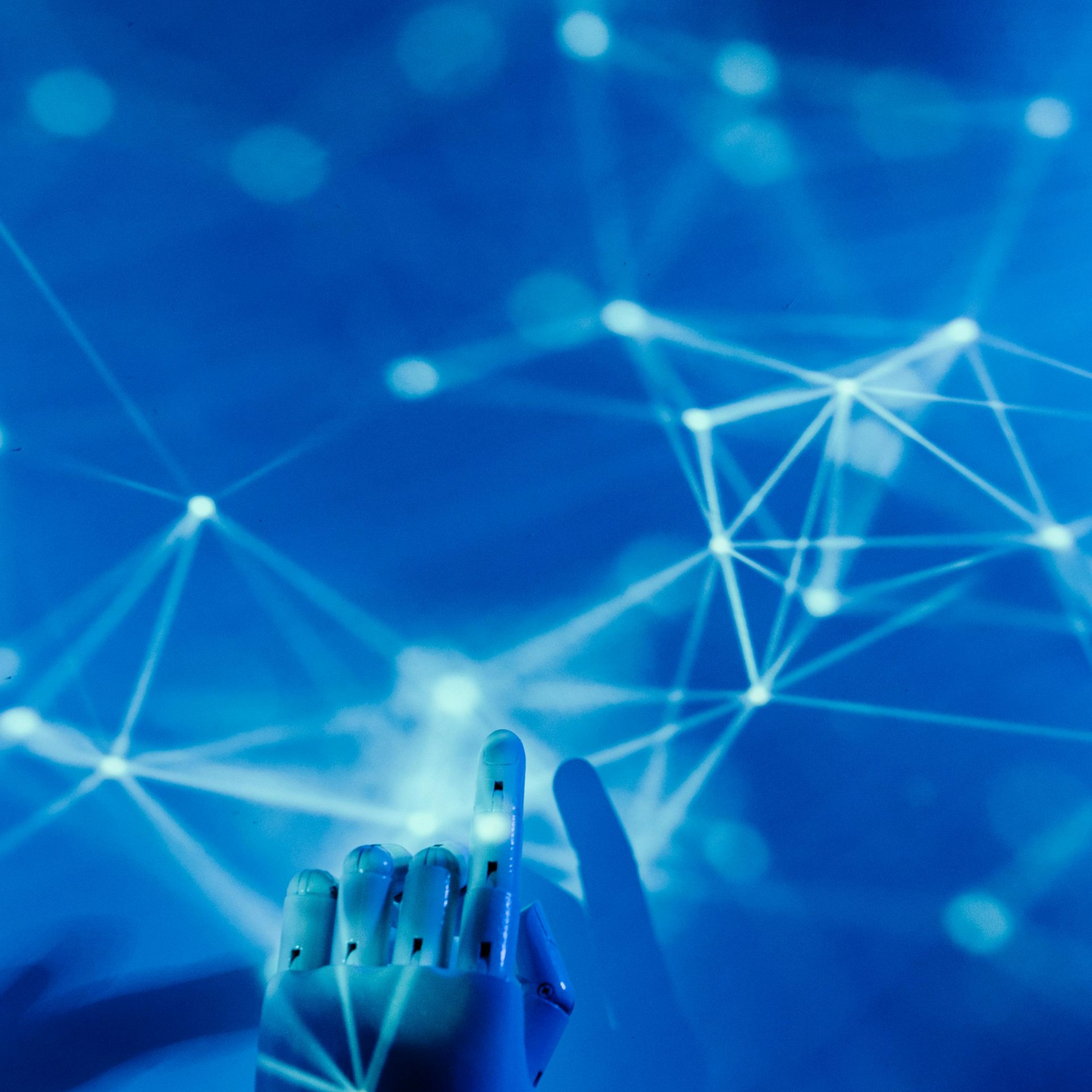 A man wearing a beanie and a black sweater is standing with his arms crossed.