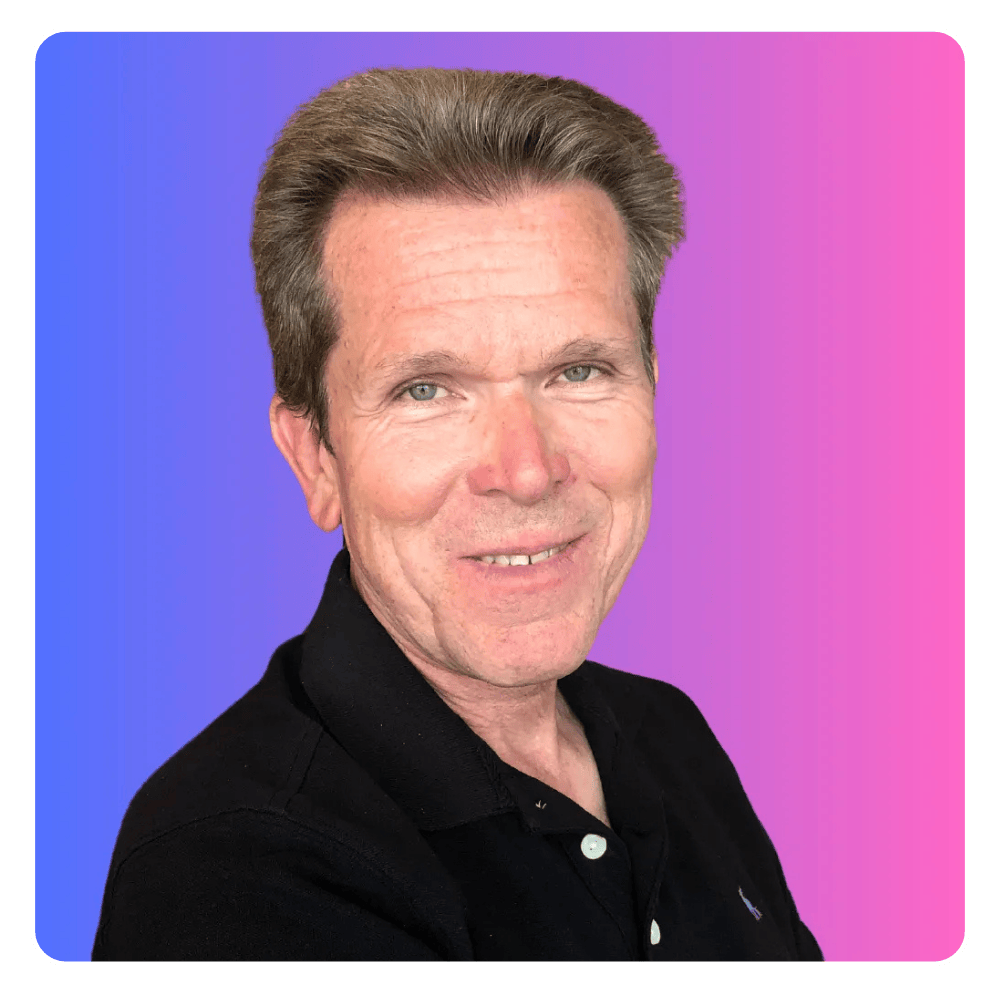 A man in a black shirt is smiling in front of a pink and blue background.