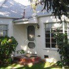 A white house with a blue roof and a lot of windows.