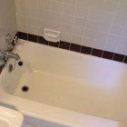 There is a bathtub in the bathroom next to a sink.