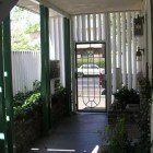 A porch with a door and a white fence.