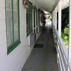 A person is walking down a long hallway between two buildings.