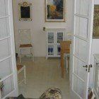 A living room with a table , chairs , and a painting on the wall.