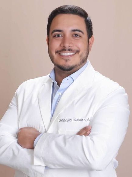 a man wearing a white lab coat with the name chris written on it