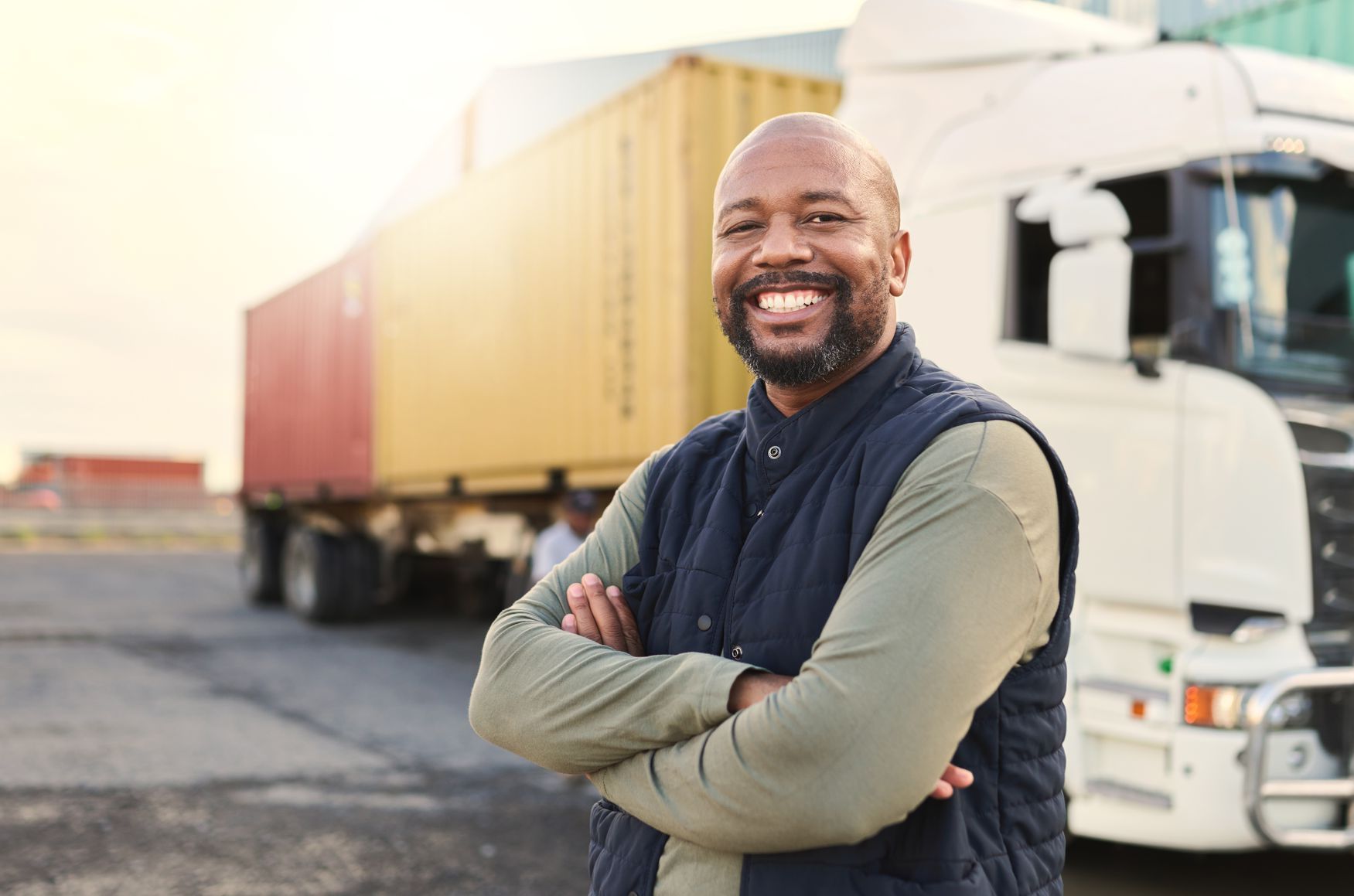middle-aged black man standing outside of his truck with arms crossed