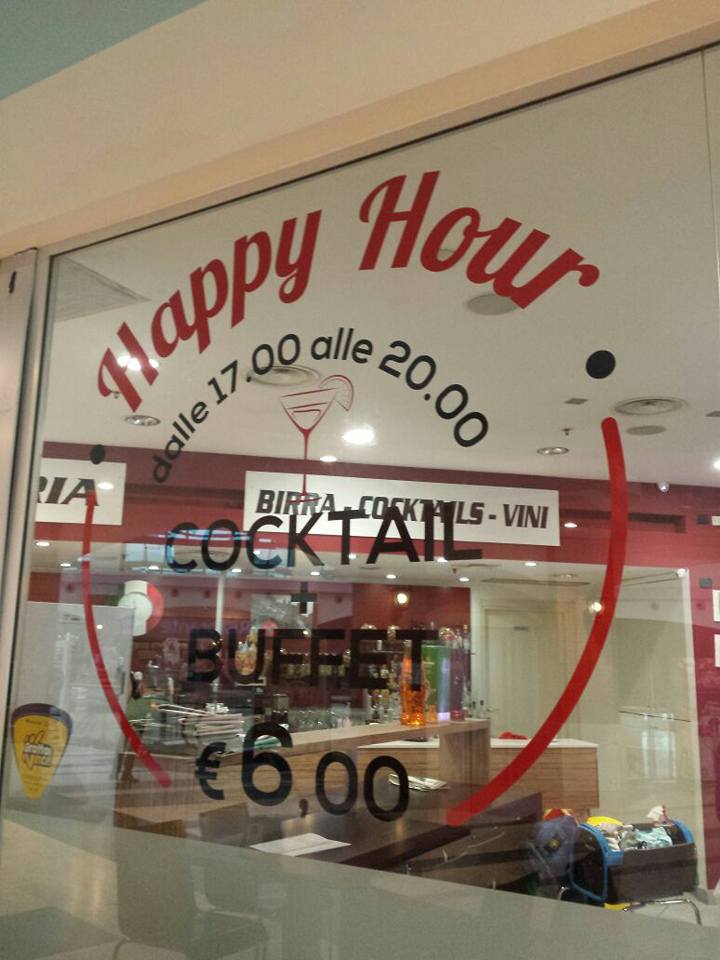 Una finestra con un cartello che dice happy hour