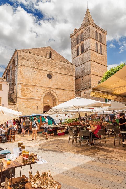 Hay una iglesia al fondo y un mercado en primer plano.