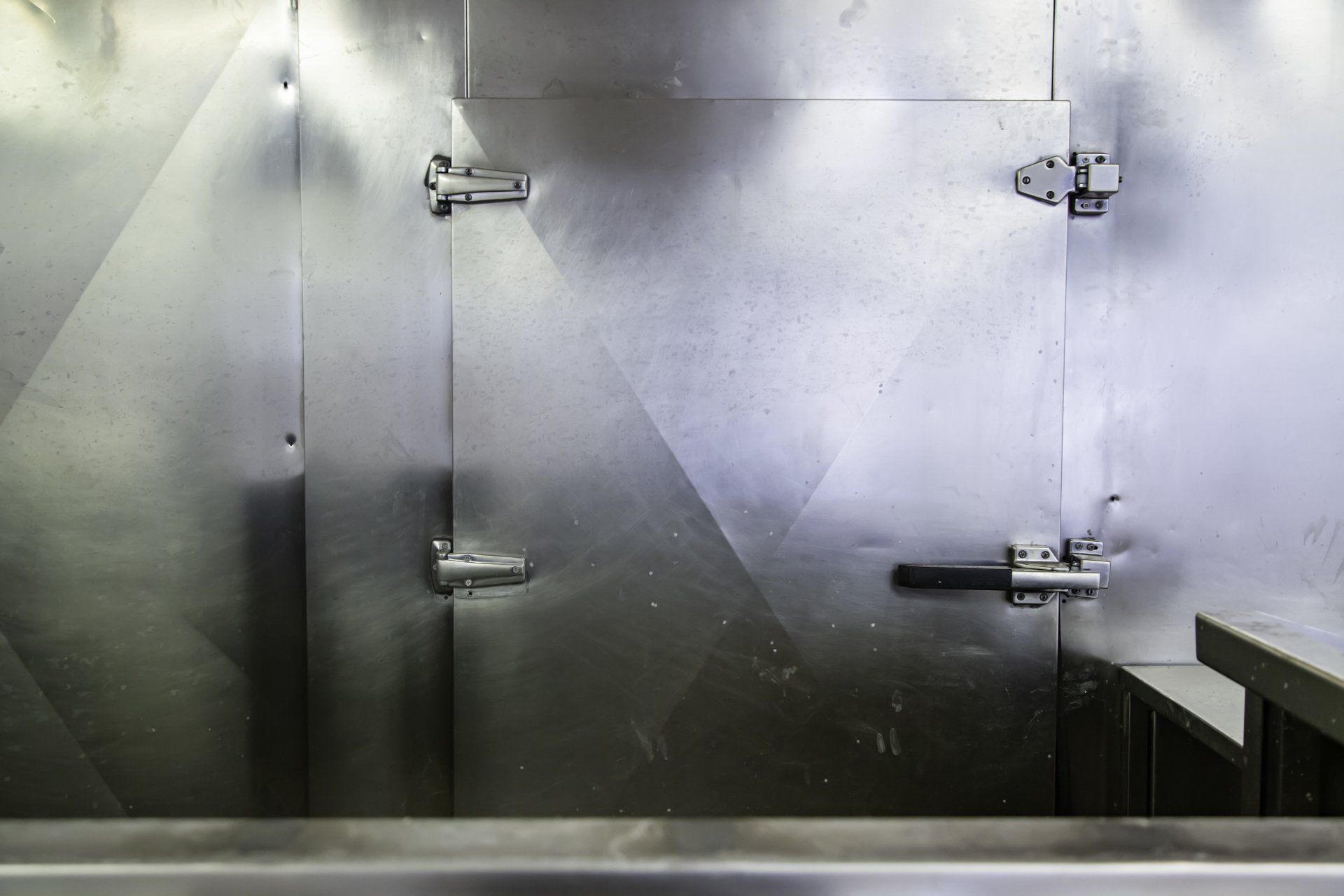 A close up of a stainless steel door in a room.