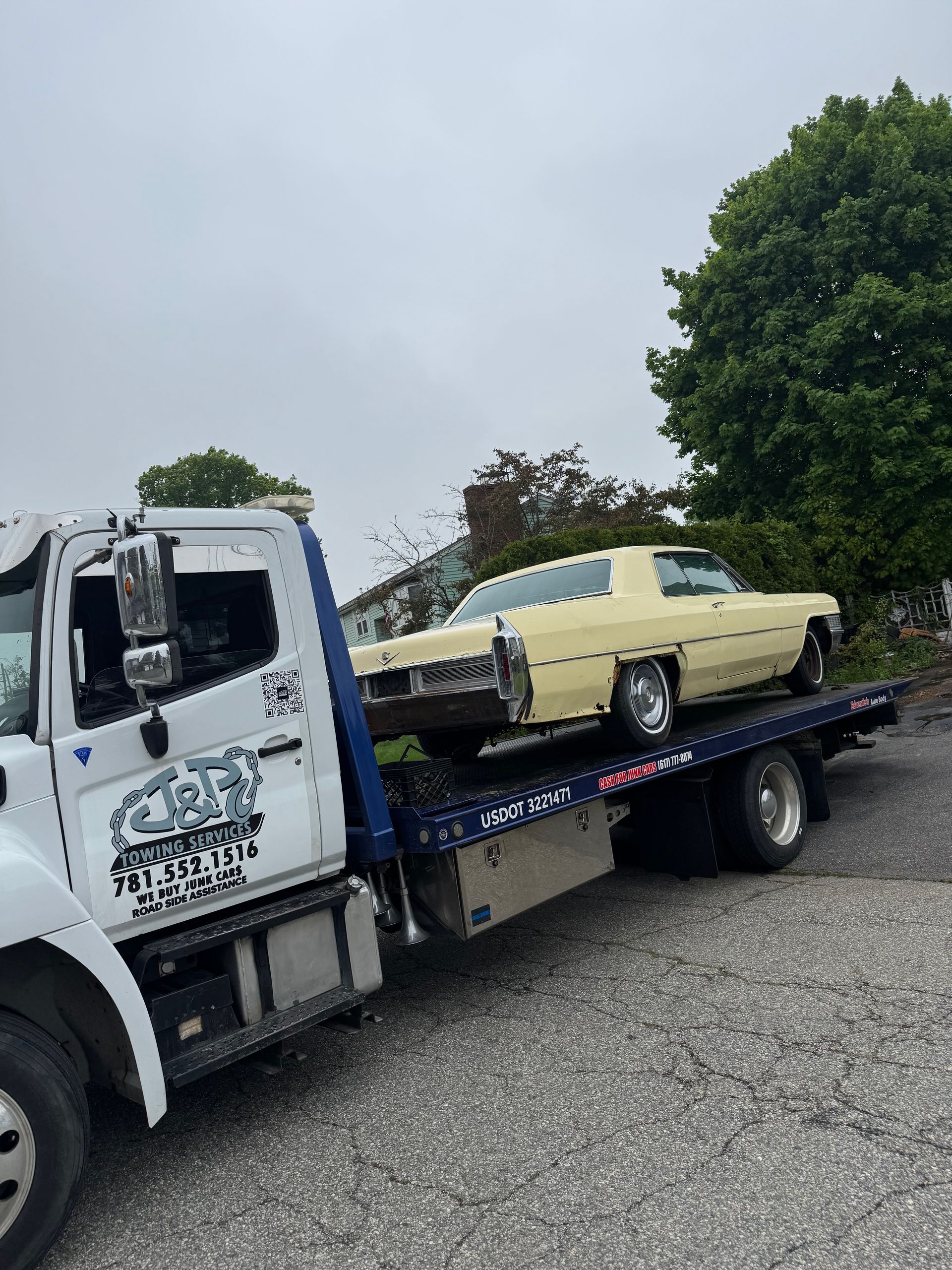 A yellow car is being towed by a tow truck.