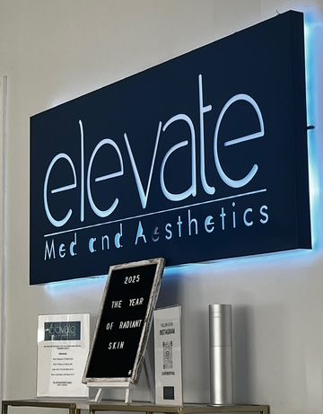 A woman in a white sweater is smiling and holding her hand to her chin.