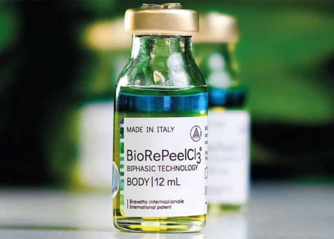 Two vials of BioRePeelCl3 chemical peel solution, made in Italy. The liquid is layered with yellow, green, and blue hues.