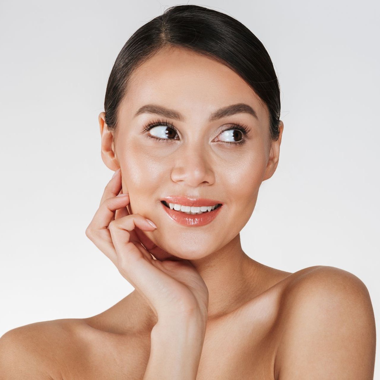 Portrait of a smiling woman touching her face over white background