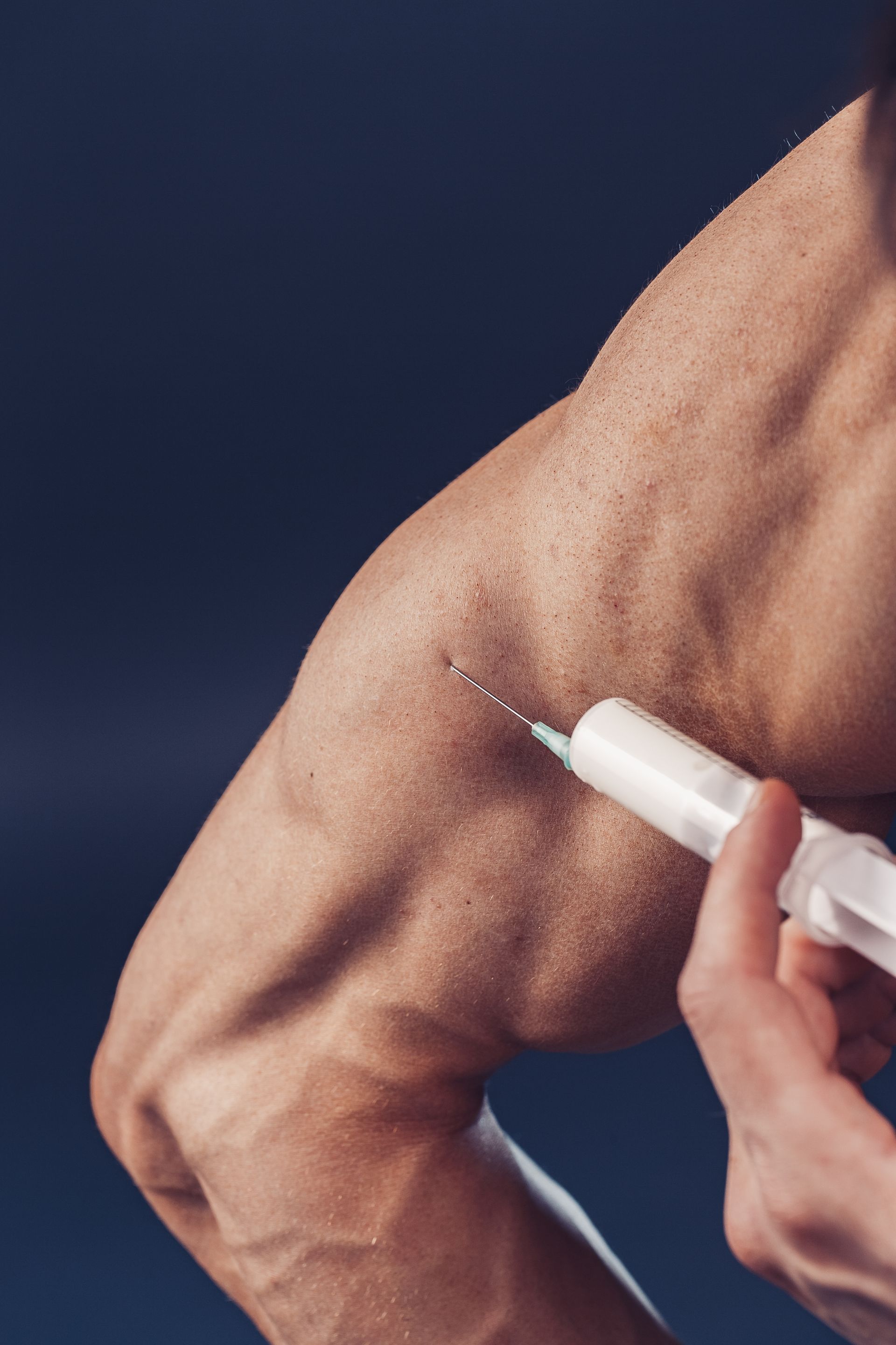 A man is getting an injection in his arm.