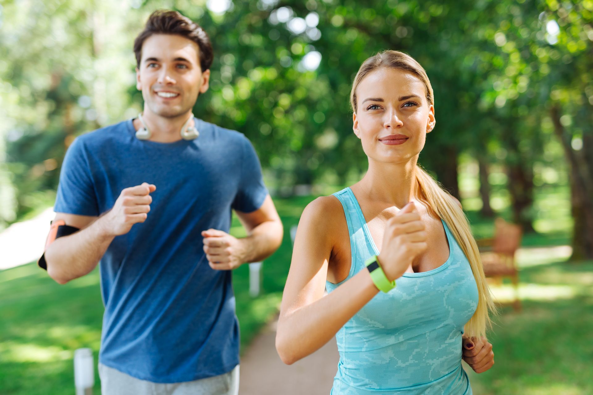 A man and a woman are jogging in a park.