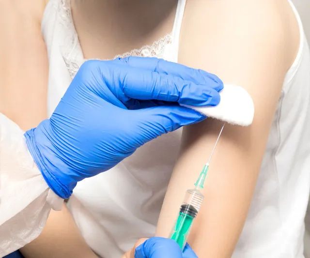 A woman is getting an injection in her arm.