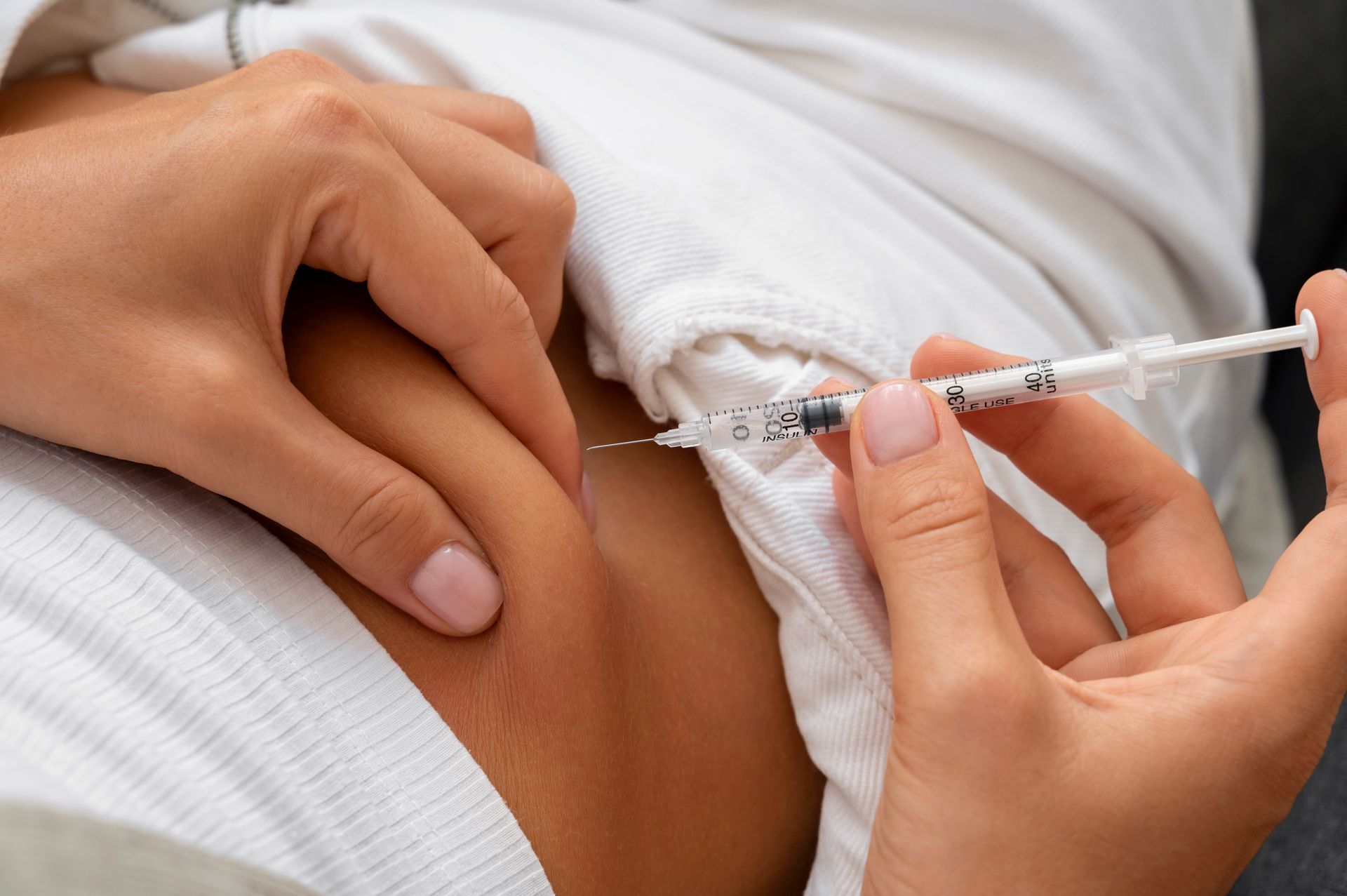 A woman is getting an injection in her arm.
