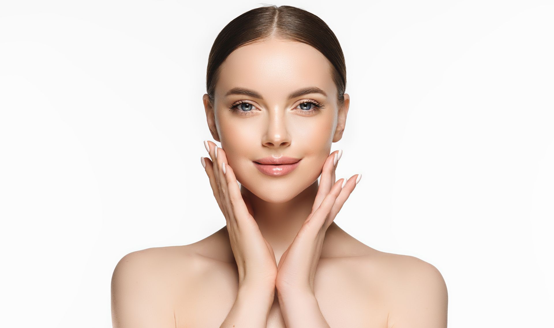 A woman is touching her face with her hands and smiling.