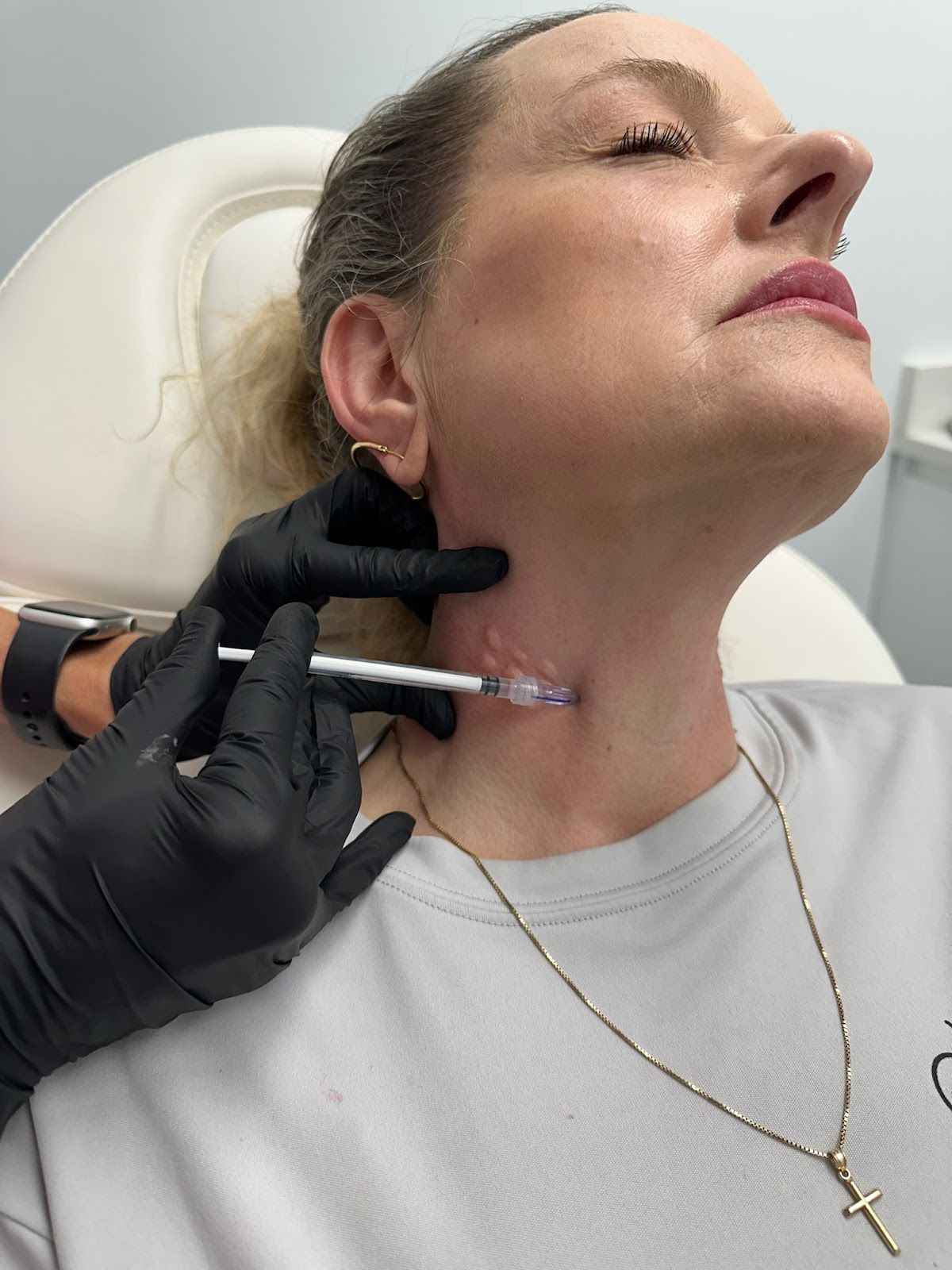A woman is getting an injection in her arm.