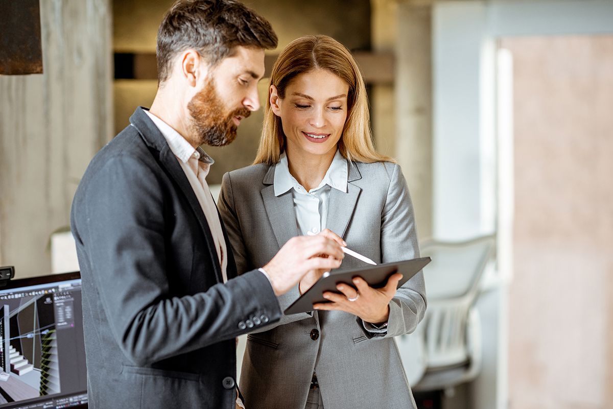A man and a woman are looking at a tablet together.