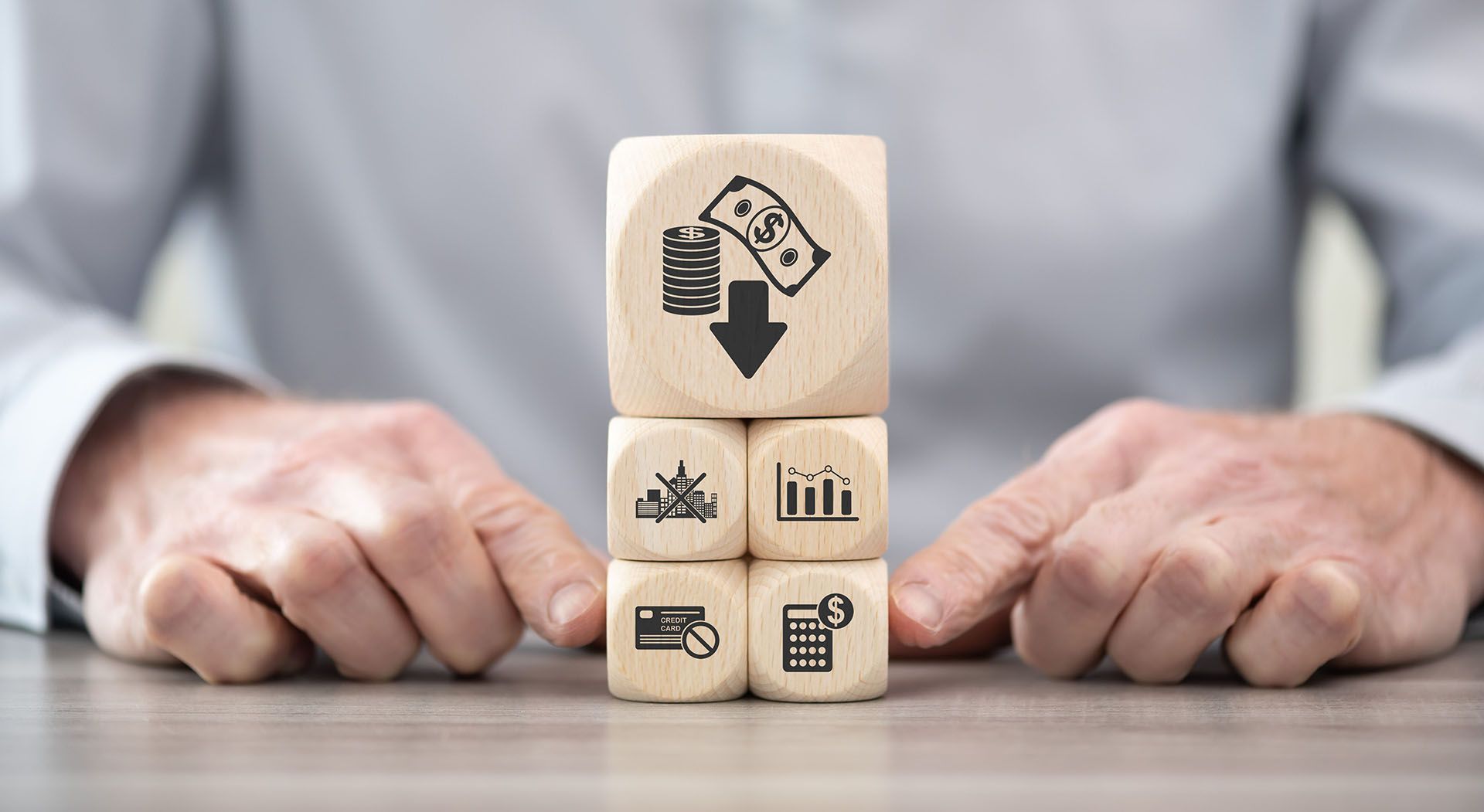 A man is stacking wooden cubes with icons on them.