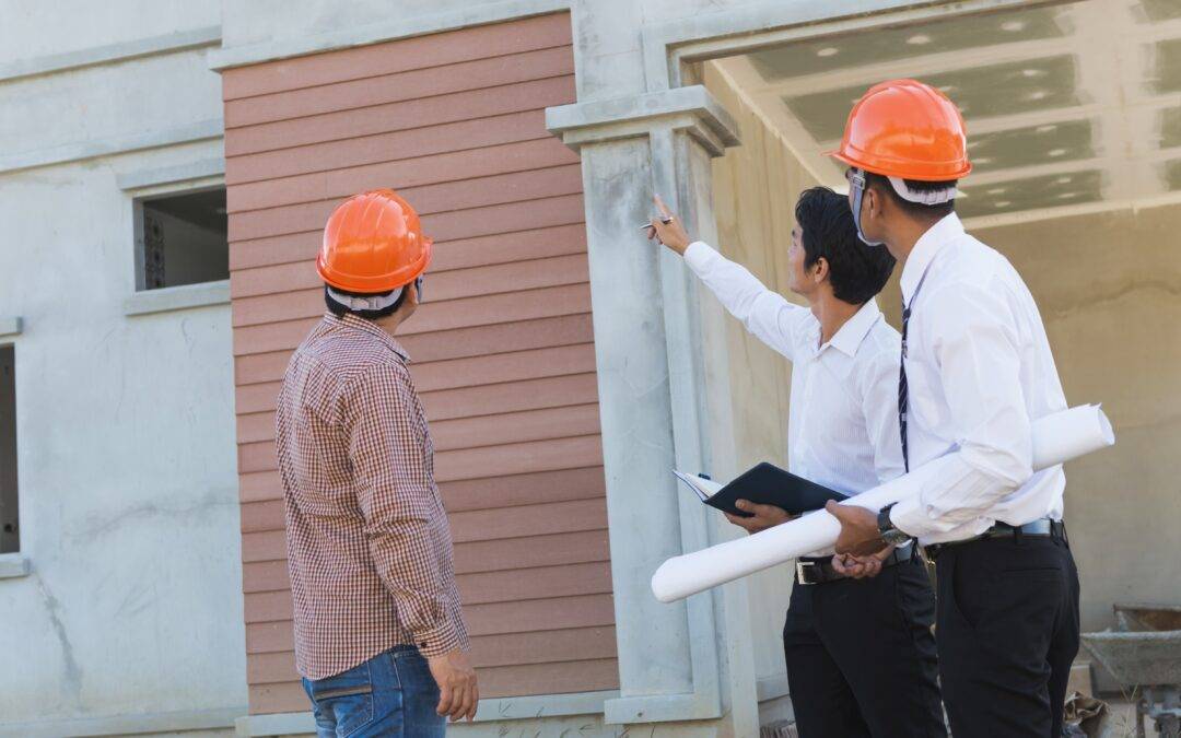 a group of construction workers are standing in front of a building under construction