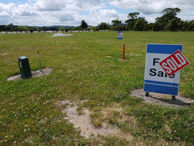a sold sign is in the middle of a grassy field