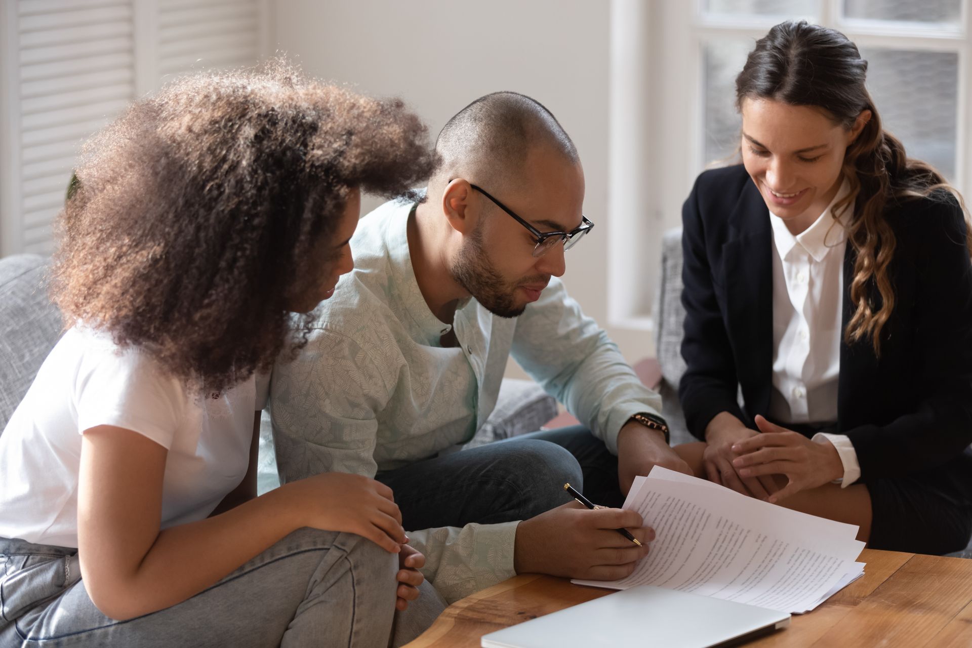 A man and a woman are sitting at a table looking at a piece of paper.