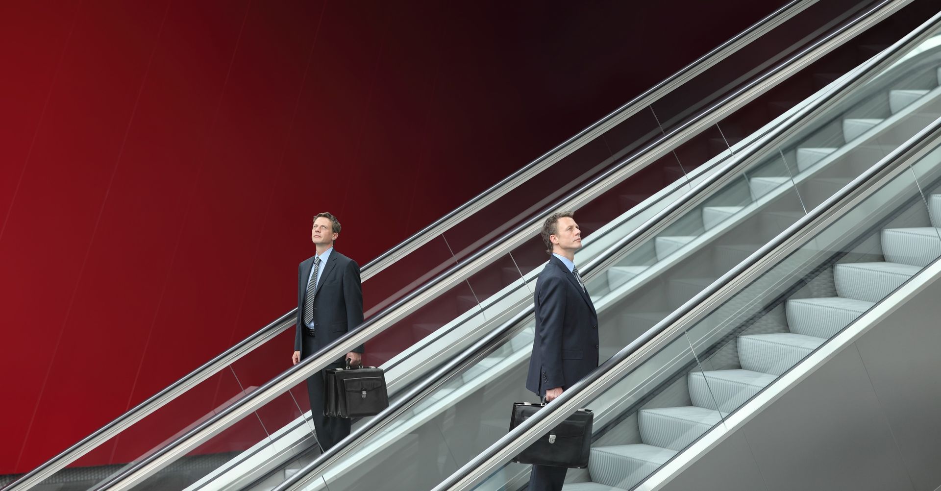 two men are walking up a set of escalators