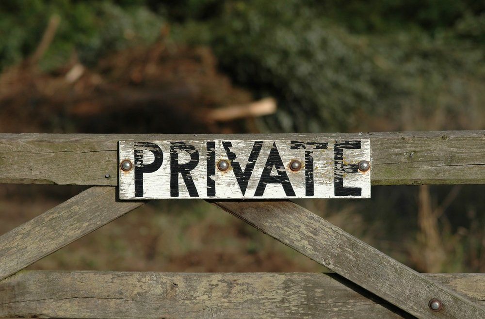 a wooden gate with a private sign on it