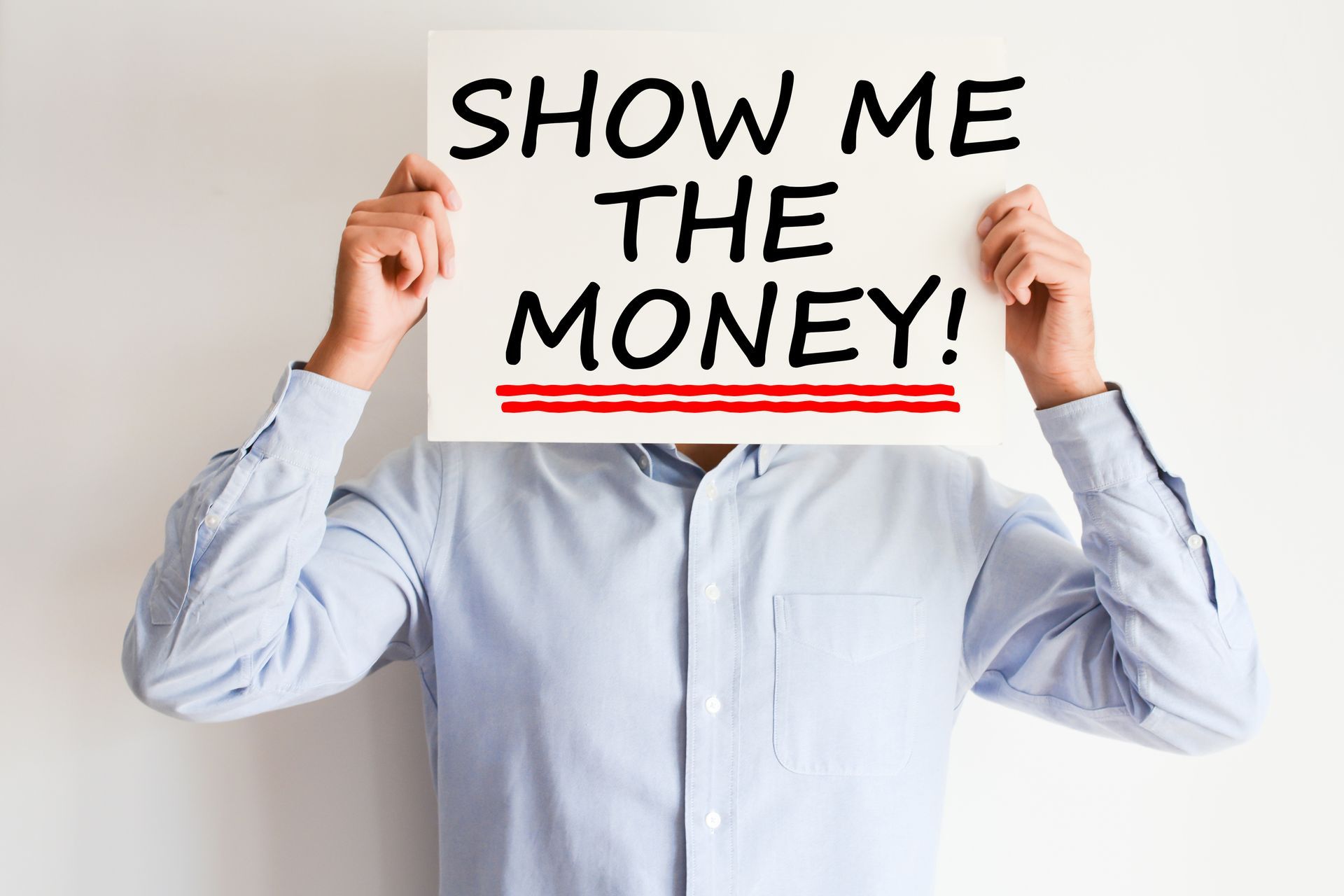 A man is holding a sign in front of his face that says 