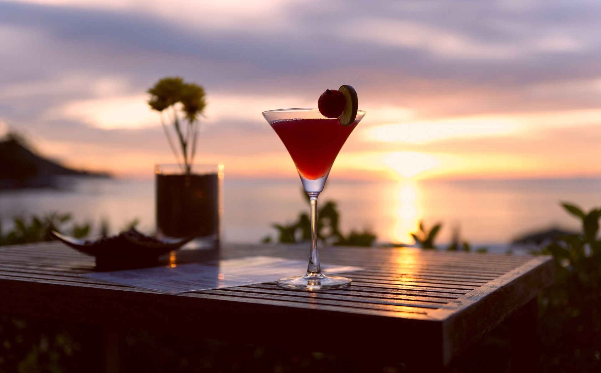 a cocktail drink with sunset in the background
