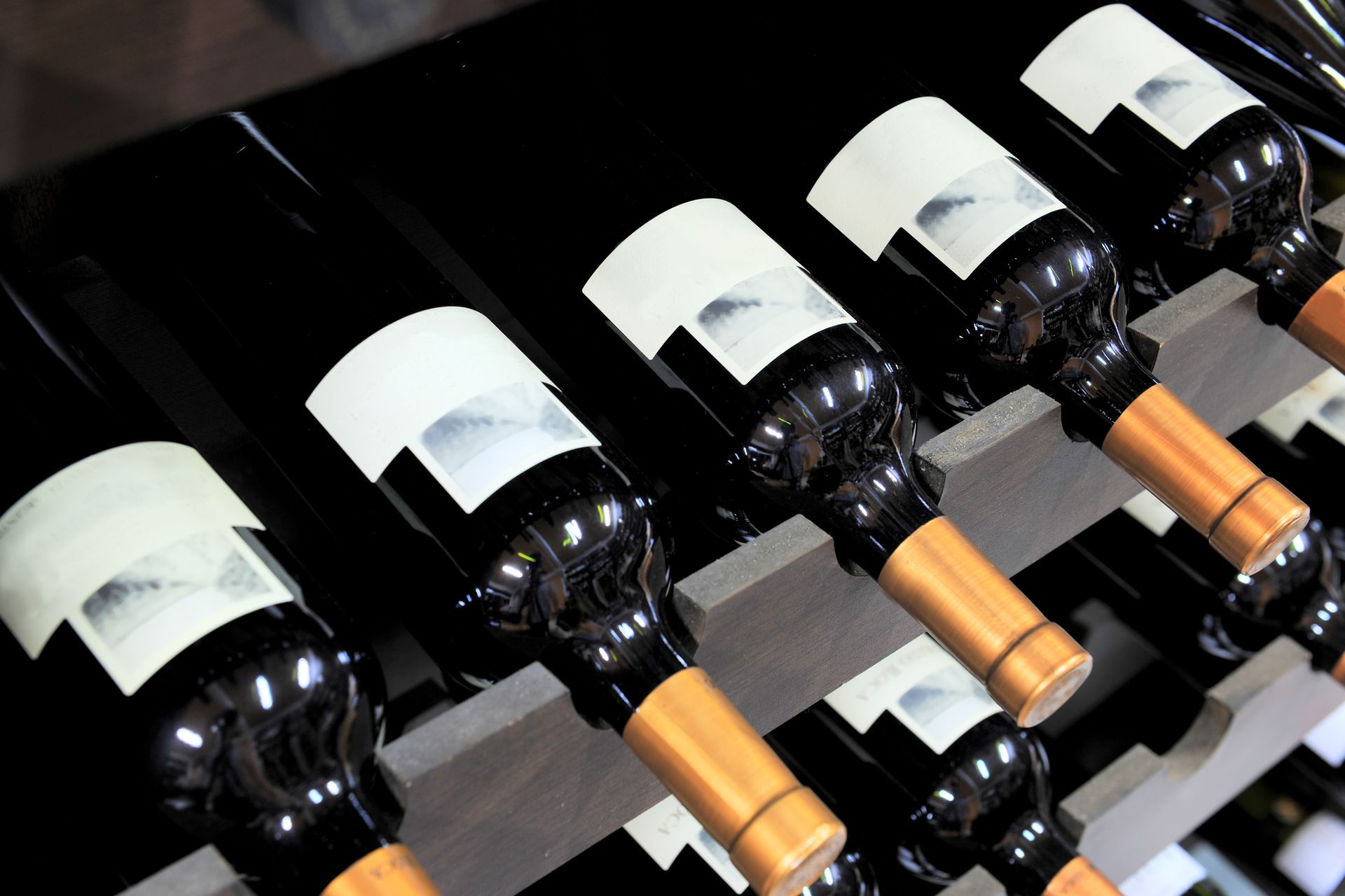 Several bottles of wine are lined up on a shelf