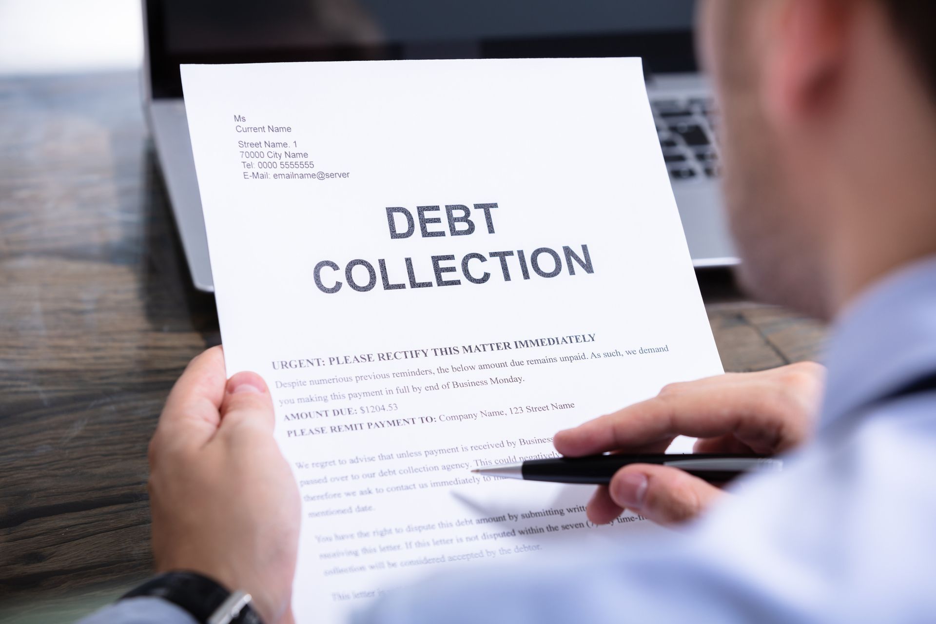 A man is holding a piece of paper that says debt collection.