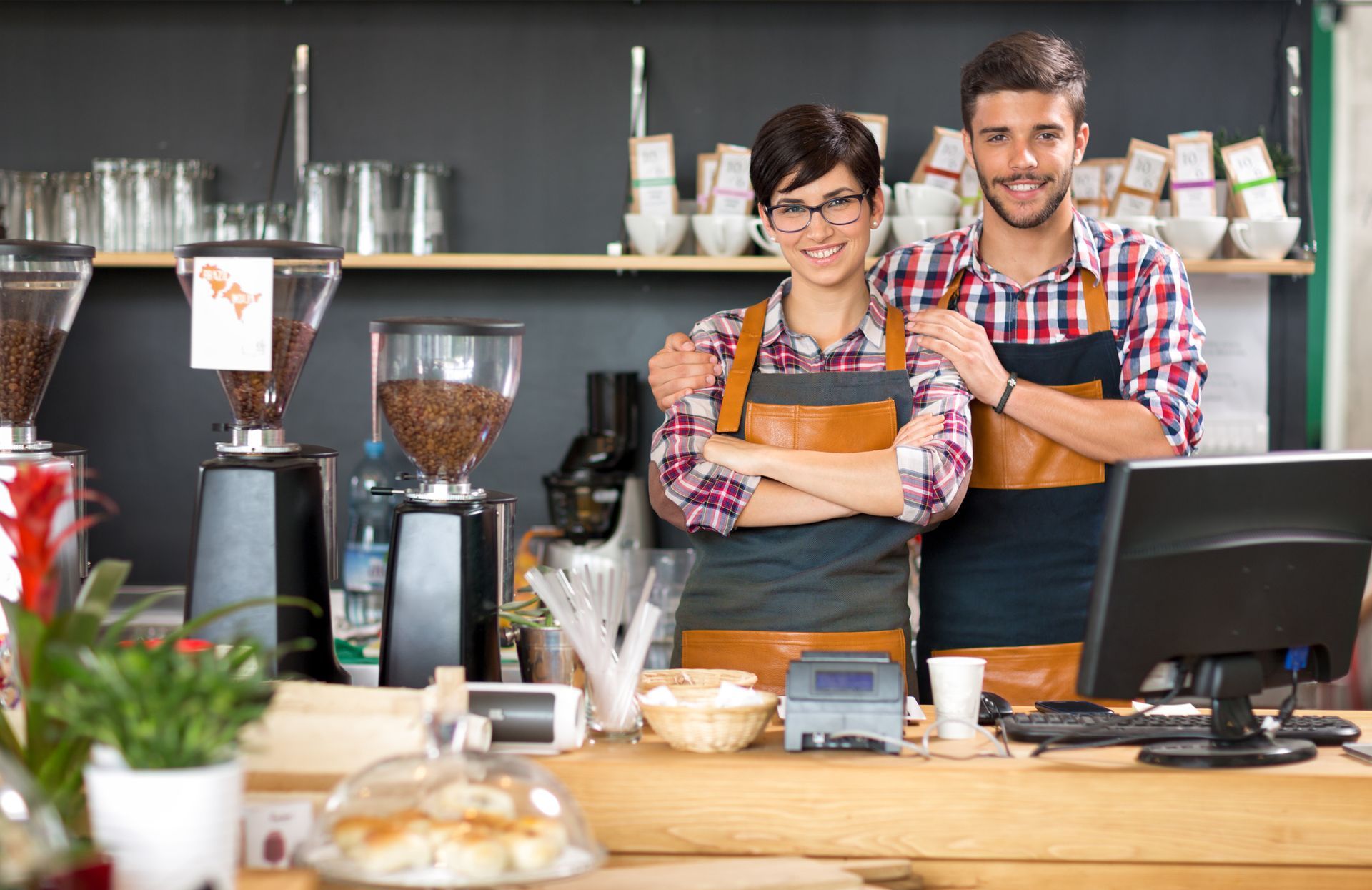 A man and a woman are posing for a picture in a coffee shop.