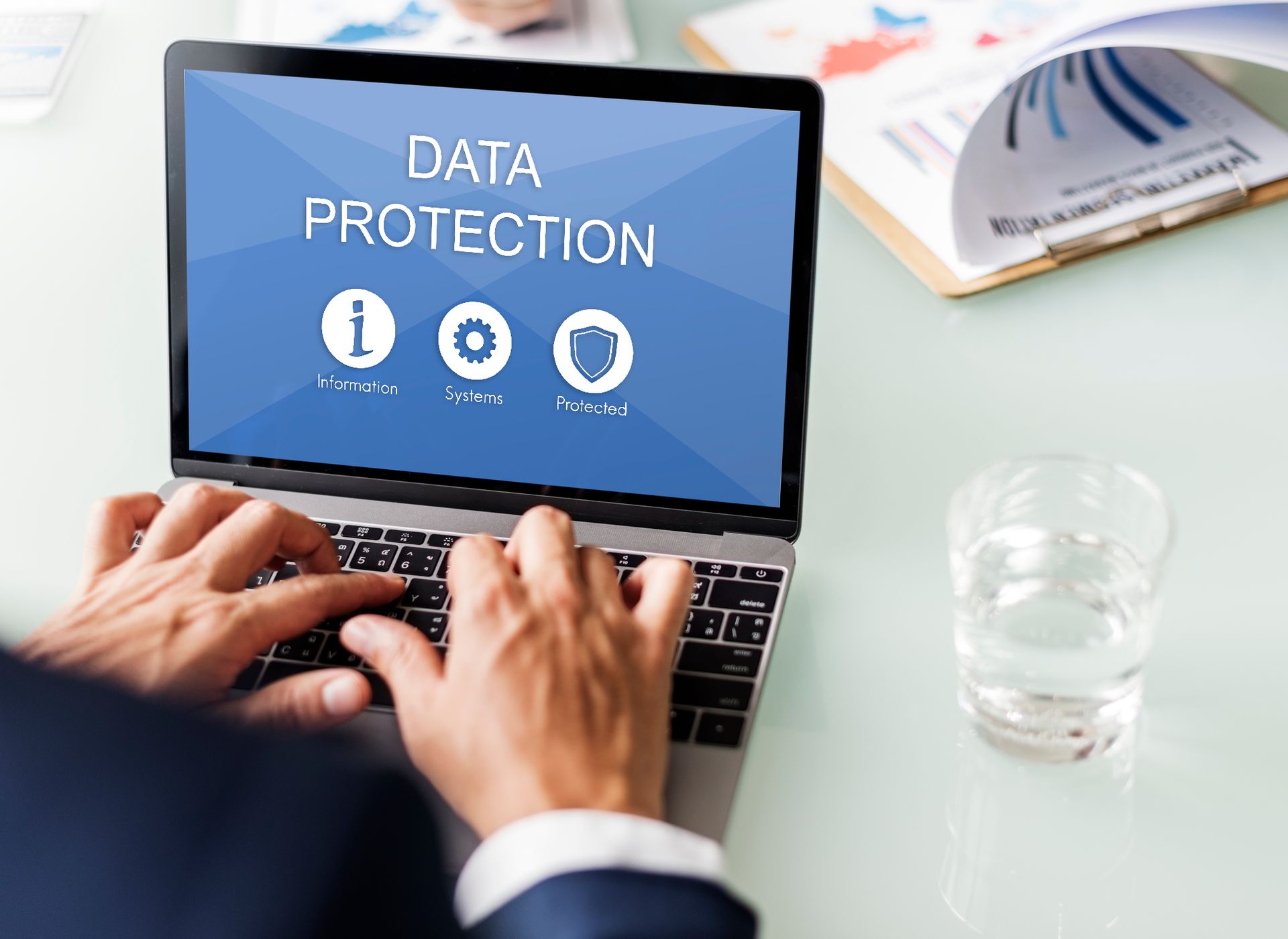 A man is typing on a laptop with the words data protection on the screen.