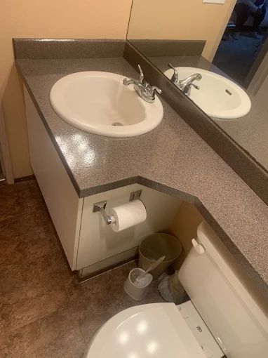 Modern bathroom with floating vanity, toilet, and glass-enclosed shower in gray and white.