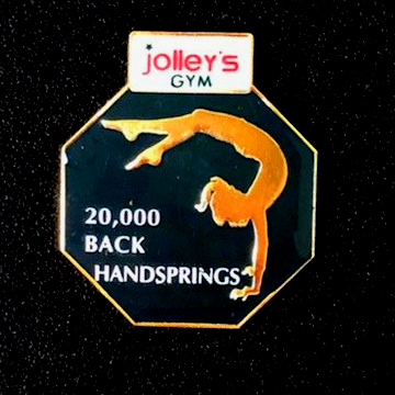 A pin for jolley 's gym has a picture of a gymnast on it